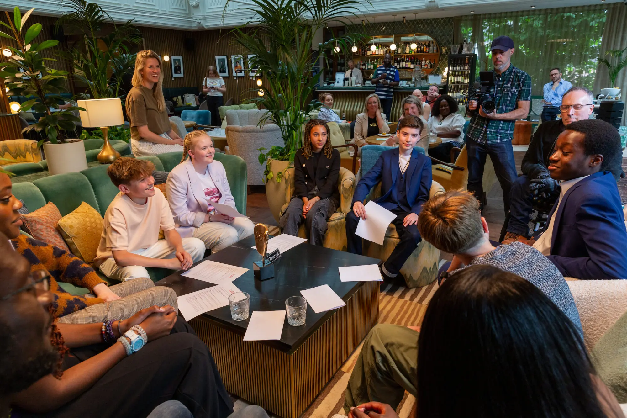 A group of young people sat around a low table with scripts in front of them having a discussion.