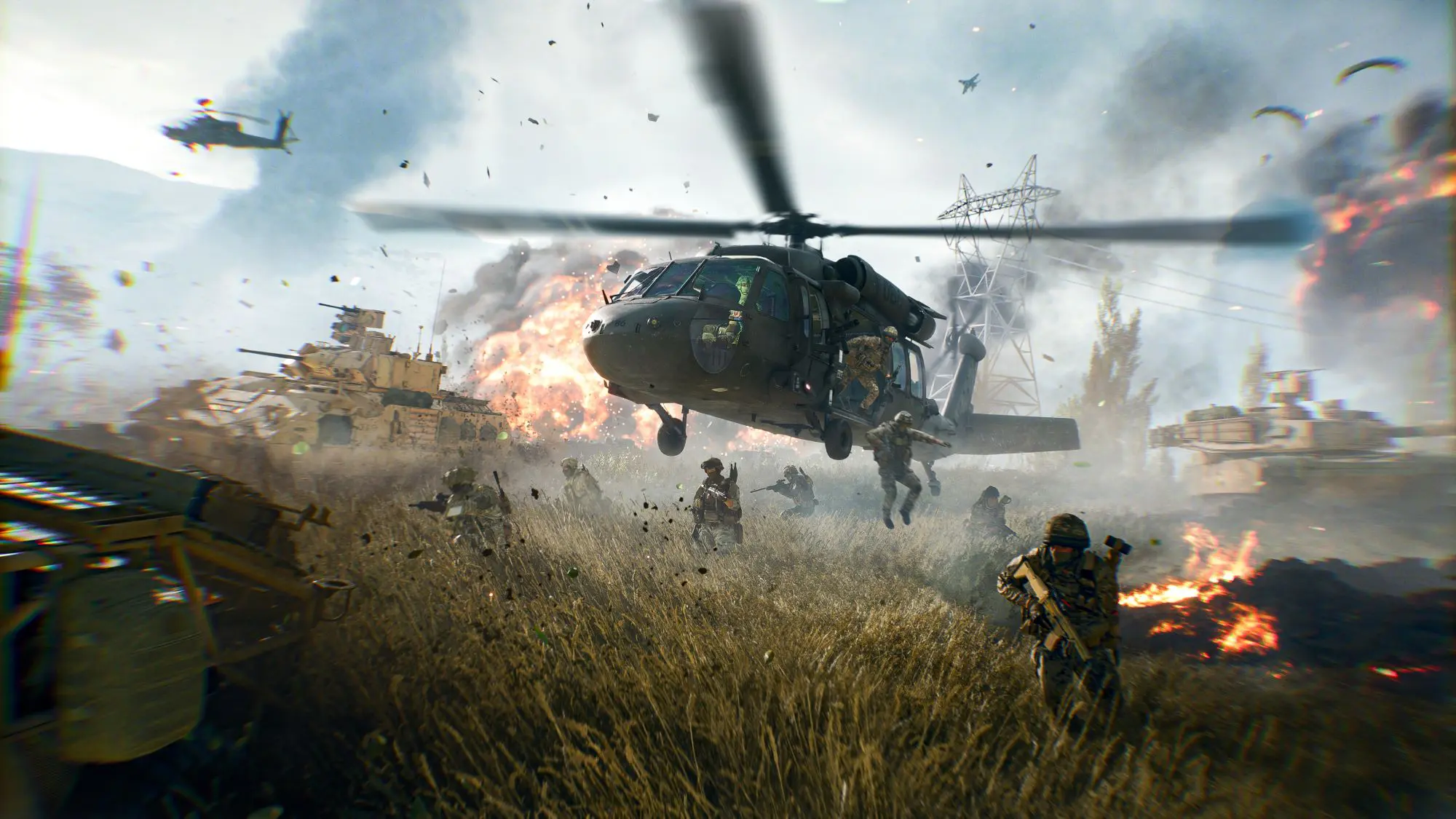 A still from the game Battlefield 6. An army helicopter hovering low over long grass as soldiers jump out the side. Large fires are ablaze in the background.