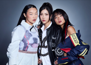 Three people standing and looking at the camera, wearing bright, colourful clothes