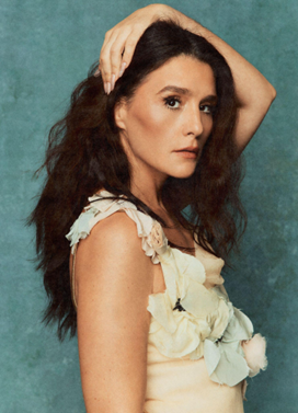 Jessie Ware facing the camera side-on, wearing a floral dress